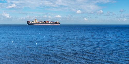 Large container cargo ship on wide blue ocean